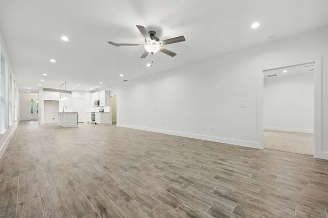 an empty room with a window and a fan