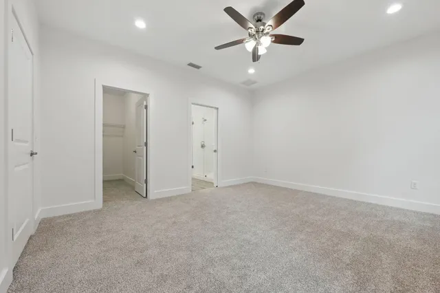 an empty room with closet and a ceiling fan