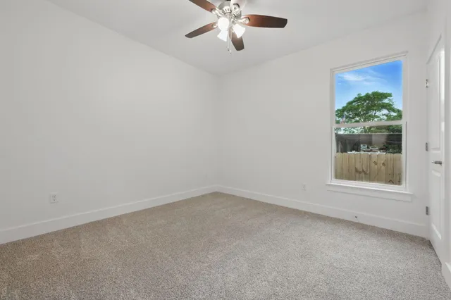 an empty room with a chandelier fan