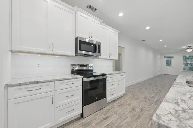 a kitchen with white cabinets and stainless steel appliances