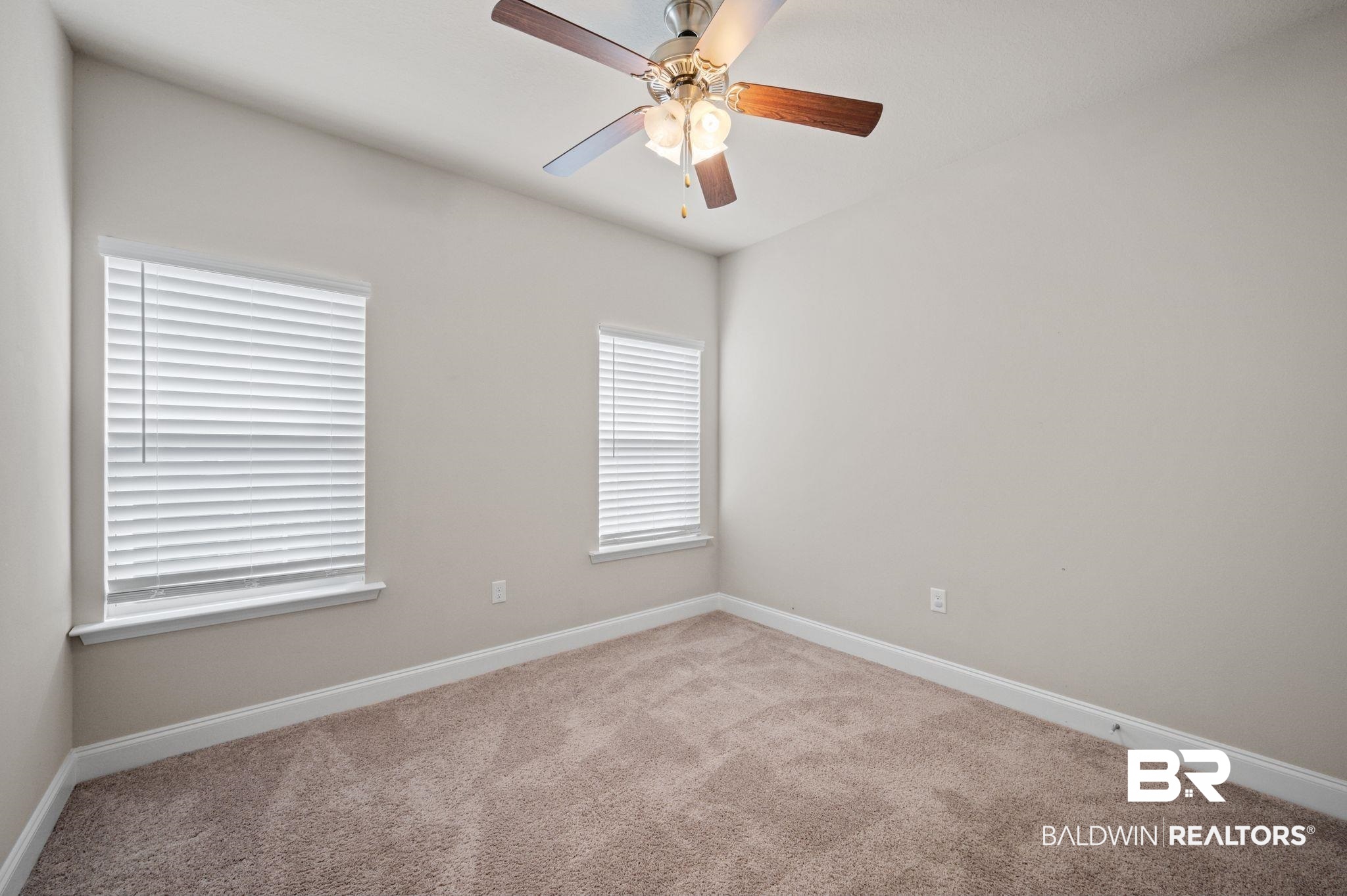 6903 Spaniel Drive, Unit B Spanish Fort, AL 36527 - Photo 18 of 28 Empty room featuring light carpet, baseboards, and a ceiling fan