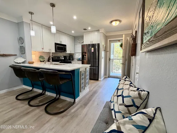 a view of a dining room with furniture a rug and wooden floor