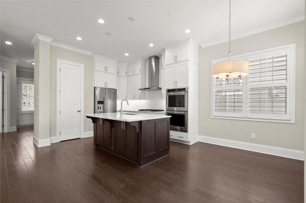293 Thompson Street Alpharetta, GA 30009 - Photo 18 of 71 a kitchen with stainless steel appliances granite countertop a sink a stove a refrigerator and a oven with wooden floor