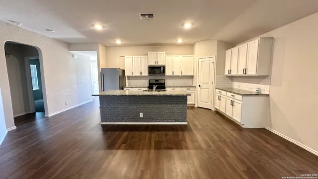 a kitchen with stainless steel appliances granite countertop a stove a sink and a refrigerator