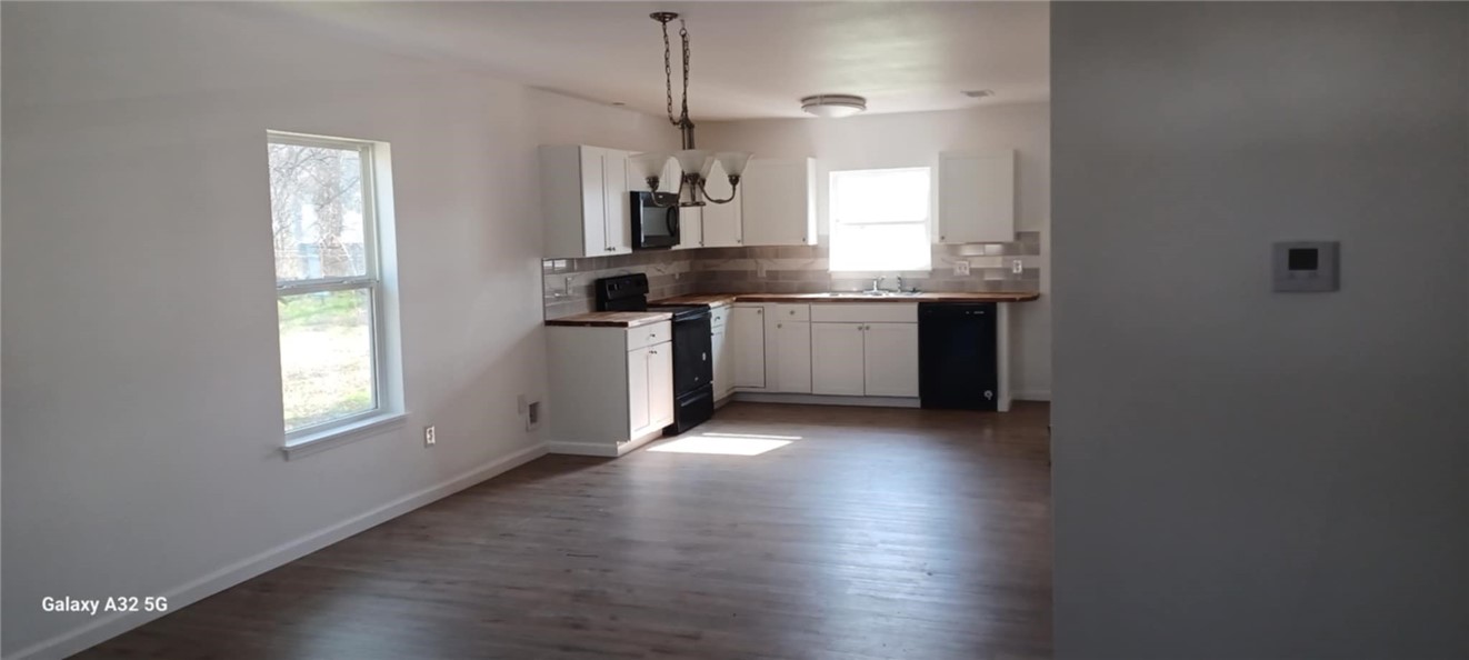 1005 Taylor Street Waco, TX 76704 - Photo 9 of 14 a kitchen with kitchen island granite countertop a stove a sink and a window