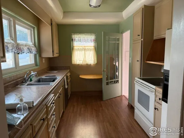 a kitchen with a sink stove top oven and refrigerator