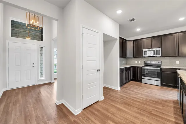 a kitchen with granite countertop a refrigerator and a stove top oven