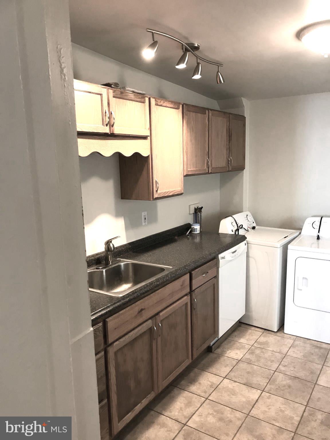 145 Levering Street Philadelphia, PA 19127 - Photo 2 of 13 a kitchen with a sink stove and cabinets