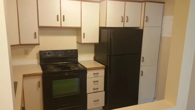a kitchen with a refrigerator and cabinets