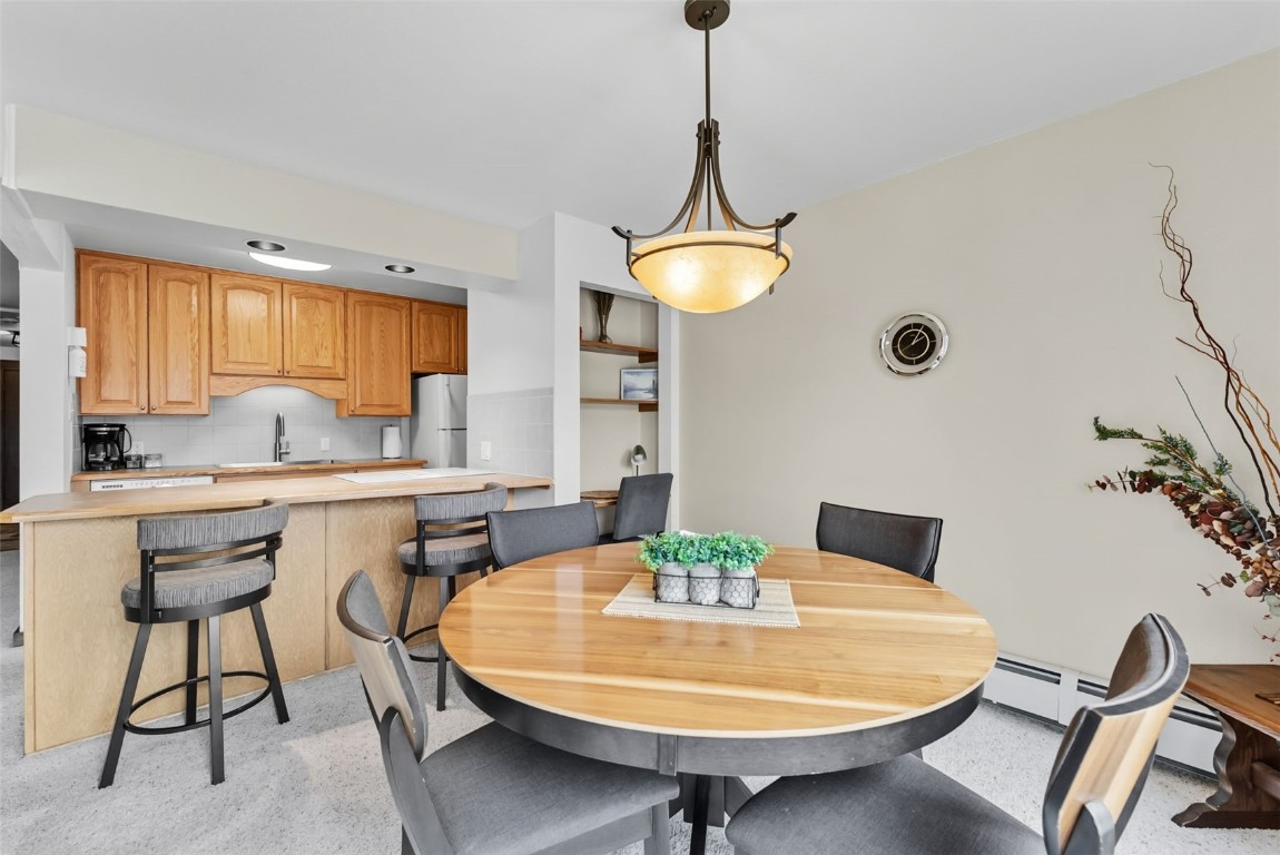 112 La Bonte Street, Unit 202 Dillon, CO 80435 - Photo 10 of 32 a kitchen with a table chairs and white cabinets