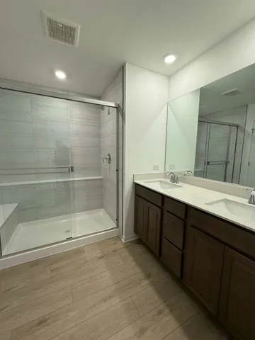 a bathroom with a double vanity sink mirror and shower