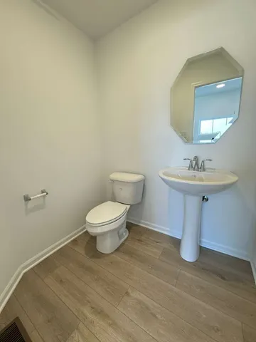 a bathroom with a sink toilet and a mirror