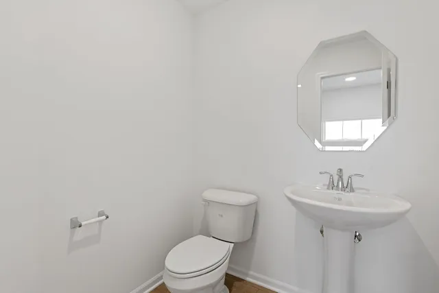 a bathroom with a sink a toilet and mirror