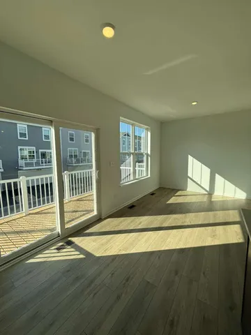 a view of a livingroom with wooden floor and a window