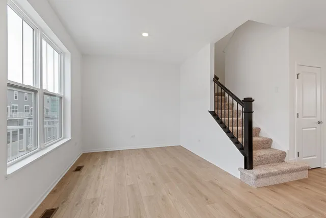 a view of a hallway with wooden floor and entryway