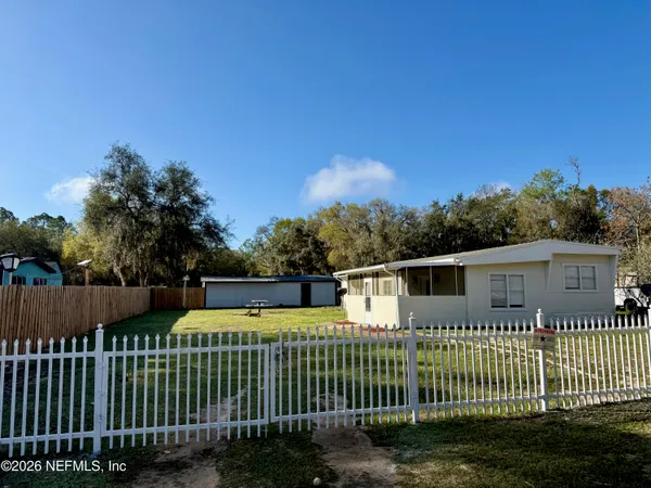 a view of a house with wooden fence