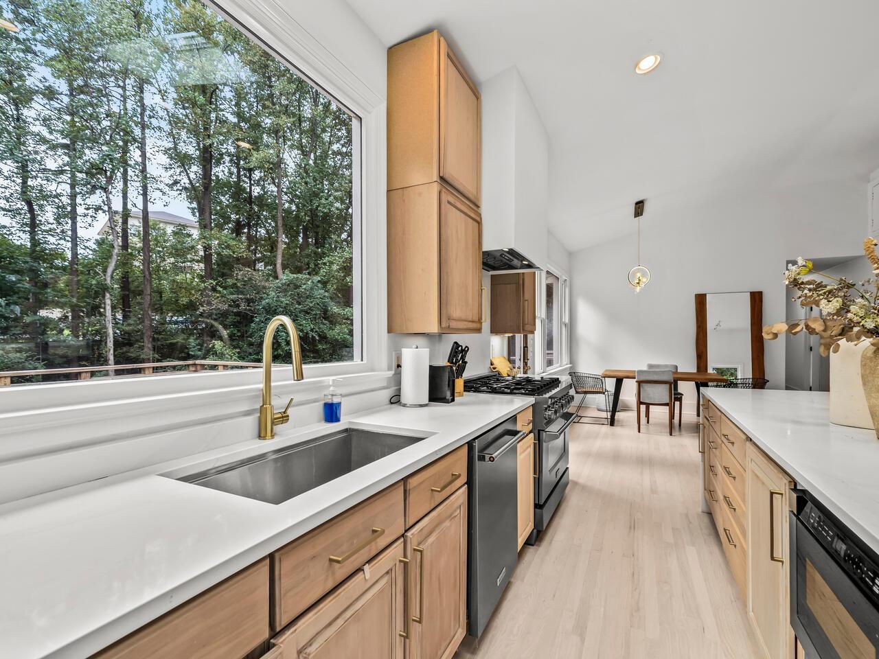 300 Dartmouth Road Raleigh, NC 27609 - Photo 11 of 28 a kitchen with stainless steel appliances a sink stove and cabinets