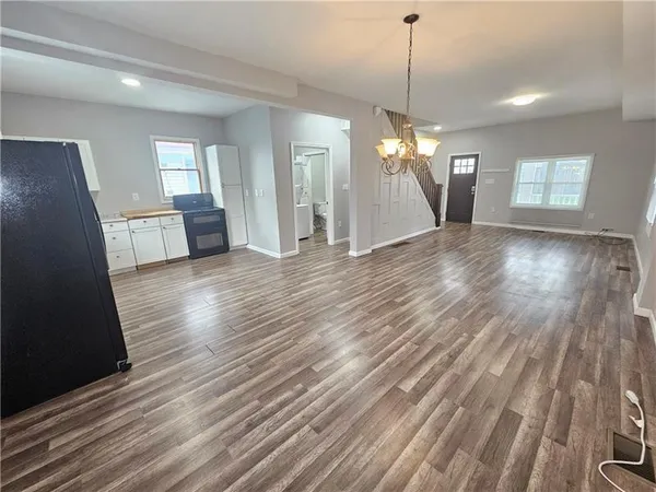 a view of a room with wooden floor staircase and a kitchen