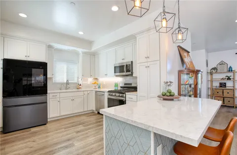 a kitchen with white cabinets and appliances