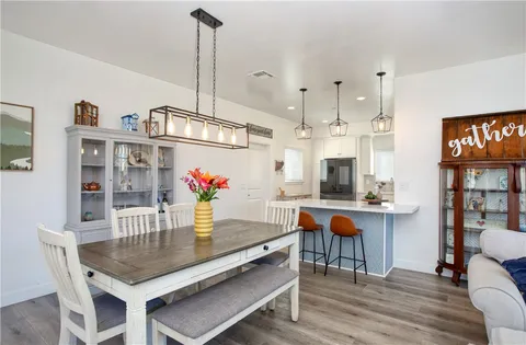 a dining room with furniture a chandelier and wooden floor