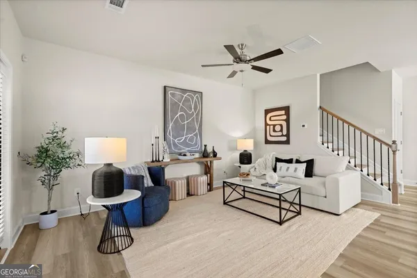 a living room with furniture and a wooden floor
