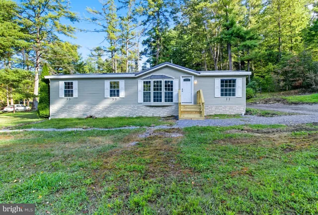 a front view of house with yard and green space