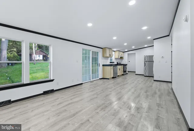 a view of empty room with wooden floor and window