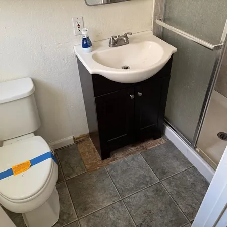 a bathroom with a sink a toilet and a mirror