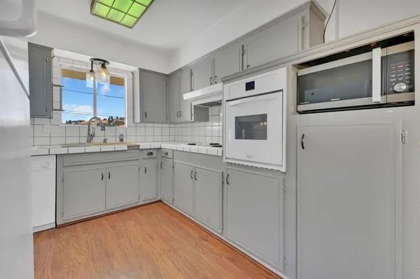 a kitchen with stainless steel appliances a white cabinets stove top oven and sink