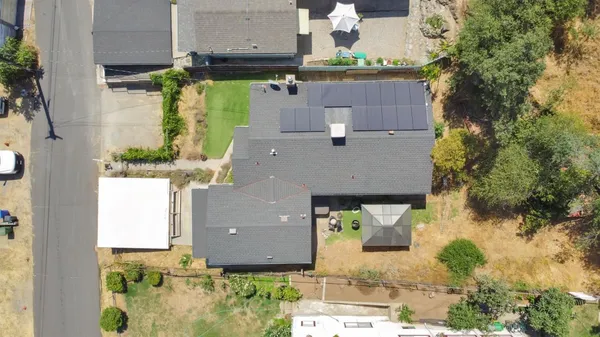 an aerial view of residential houses with outdoor space and parking