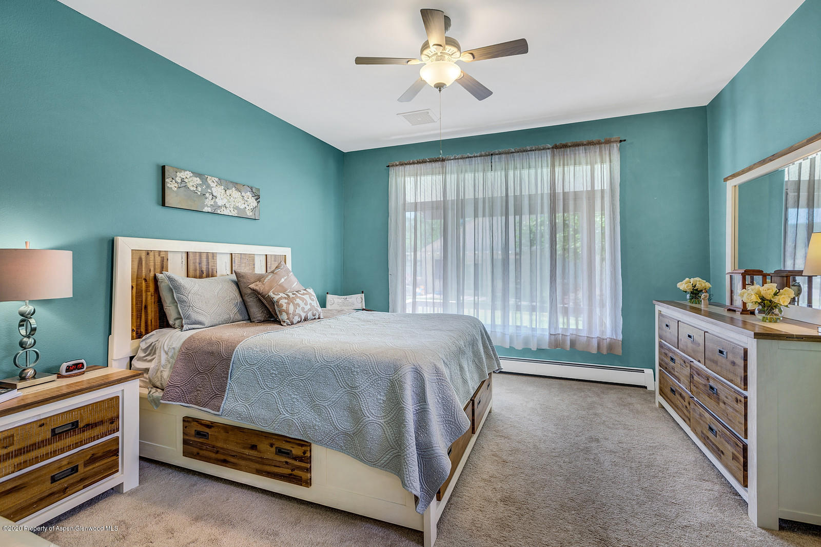 12 Poppy Court Parachute, CO 81635 - Photo 14 of 25 a spacious bedroom with a bed and a chandelier