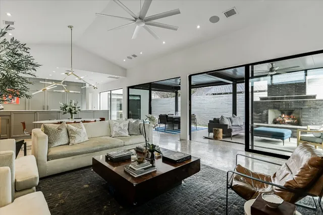 a living room with furniture a flat screen tv and a floor to ceiling window