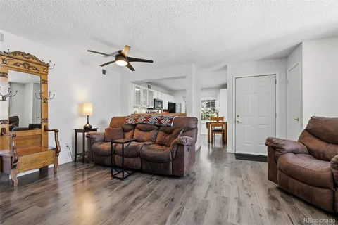 a living room with furniture a fireplace and a large window