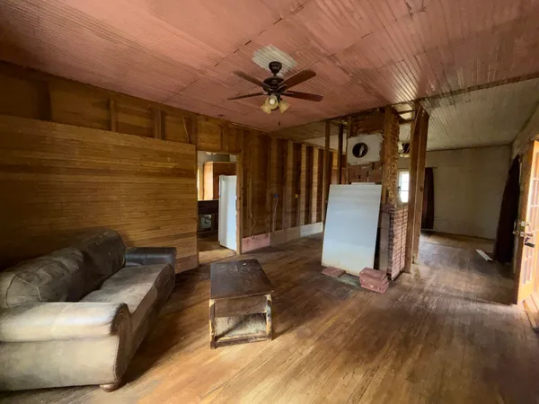 a view of a livingroom with furniture and a ceiling fan