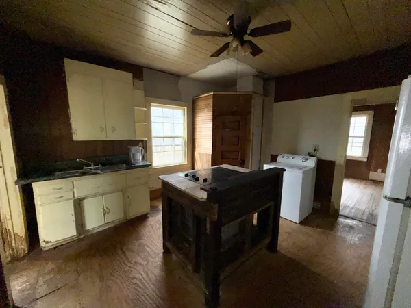 a kitchen with stainless steel appliances granite countertop a stove a refrigerator a sink and a dining table with wooden floor