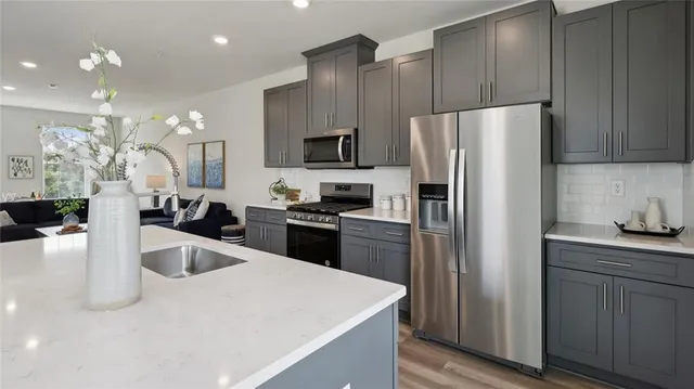 a kitchen with a refrigerator a sink a stove and cabinets