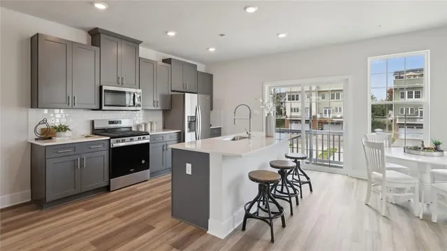 a kitchen with stainless steel appliances kitchen island granite countertop a stove a sink a refrigerator and cabinets