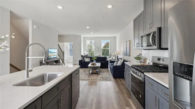 a large kitchen with stainless steel appliances granite countertop a lot of counter space and wooden floors