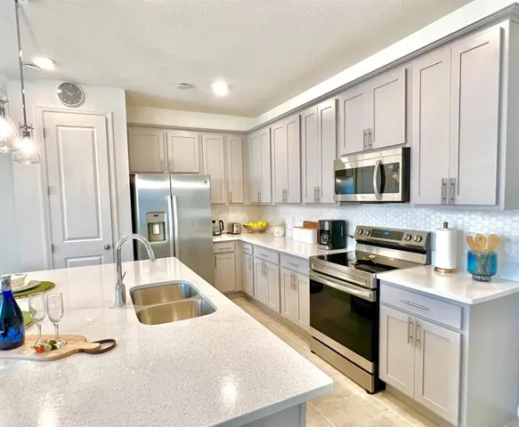 a kitchen with stainless steel appliances granite countertop a sink a stove and refrigerator