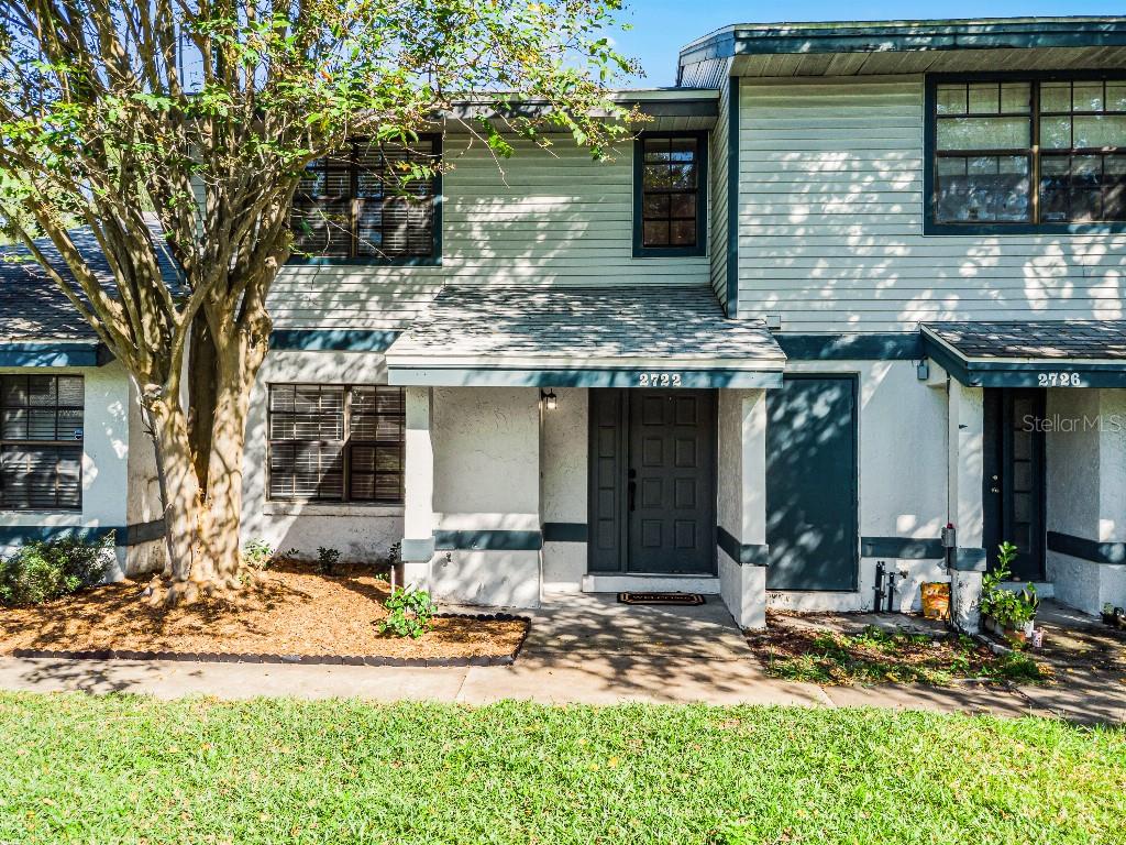 2722 Graduate Court Orlando, FL 32826 - Photo 1 of 1 a front view of a house with a yard outdoor seating and covered with trees