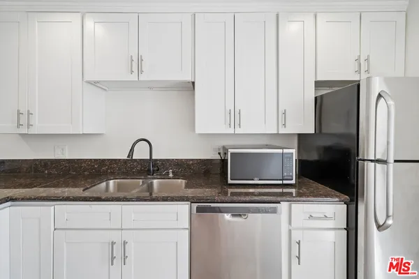 a kitchen with a stove and white cabinets