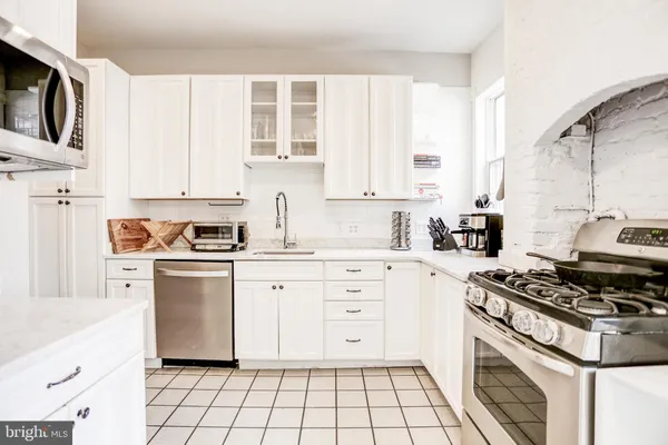 a kitchen with cabinets appliances and a window