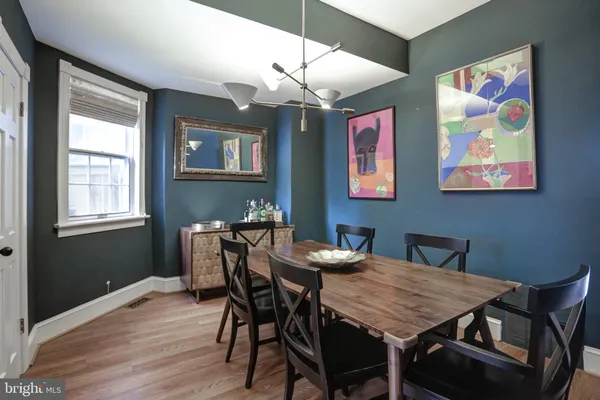 a view of a dining room with furniture a chandelier and wooden floor