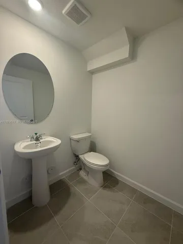 a bathroom with a toilet a sink and mirror