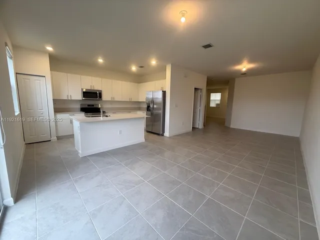 a kitchen with stainless steel appliances a refrigerator sink and microwave