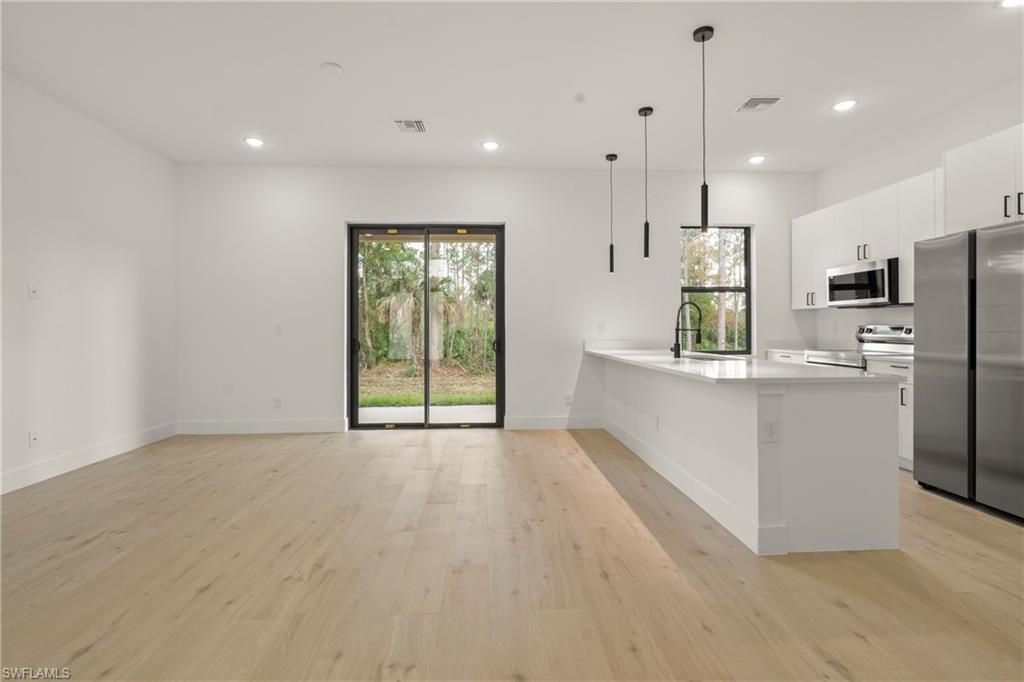 2717 20th Street West Lehigh Acres, FL 33971 - Photo 19 of 20 a view of kitchen with stainless steel appliances refrigerator oven and microwave