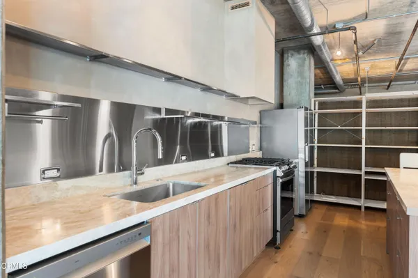 a kitchen with kitchen island a stove and a sink
