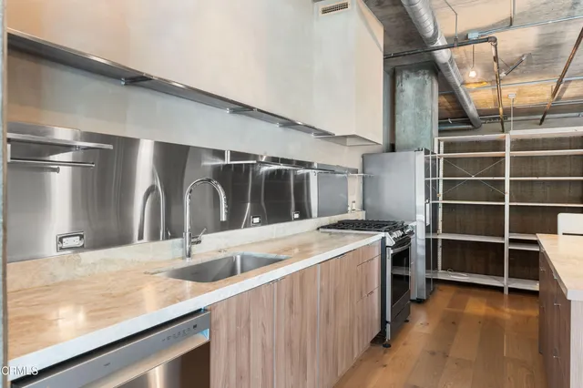 a kitchen with kitchen island a stove and a sink