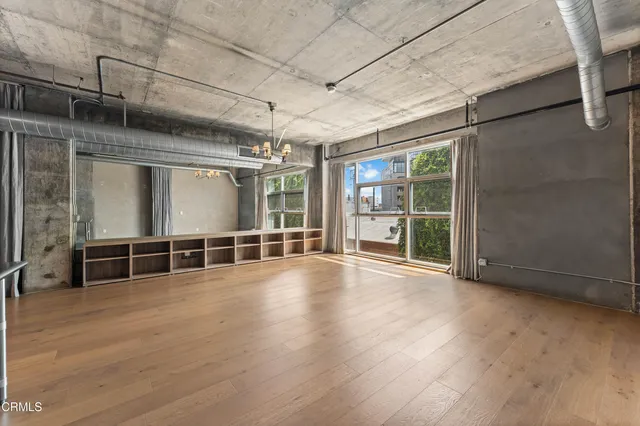 a view of empty room with wooden floor and windows