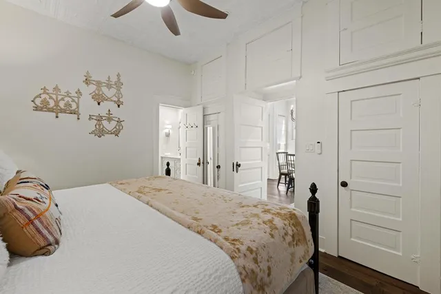 a walk in closet with wooden floor and a bedroom